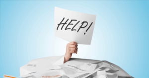 (pile of bills with a hand holding up a sign that reads “help!”)