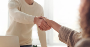 (Close-up of a handshake between two people, symbolizing trust, agreement, and professional support in resolving debt.)
