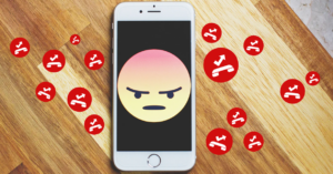 (A smartphone shows an angry emoji surrounded by red debt icons, symbolizing financial stress and rising balances—ideal for topics on credit or consumer frustration.)