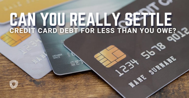 (A close-up of several credit cards spread out on a wooden surface, with the text “Can You Really Settle Credit Card Debt for Less Than You Owe?” displayed across the image.)